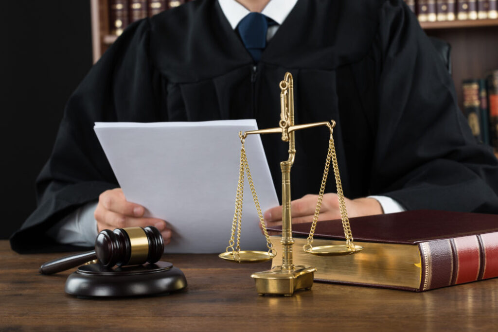 Judge Reading Documents At Desk In Courtroom
