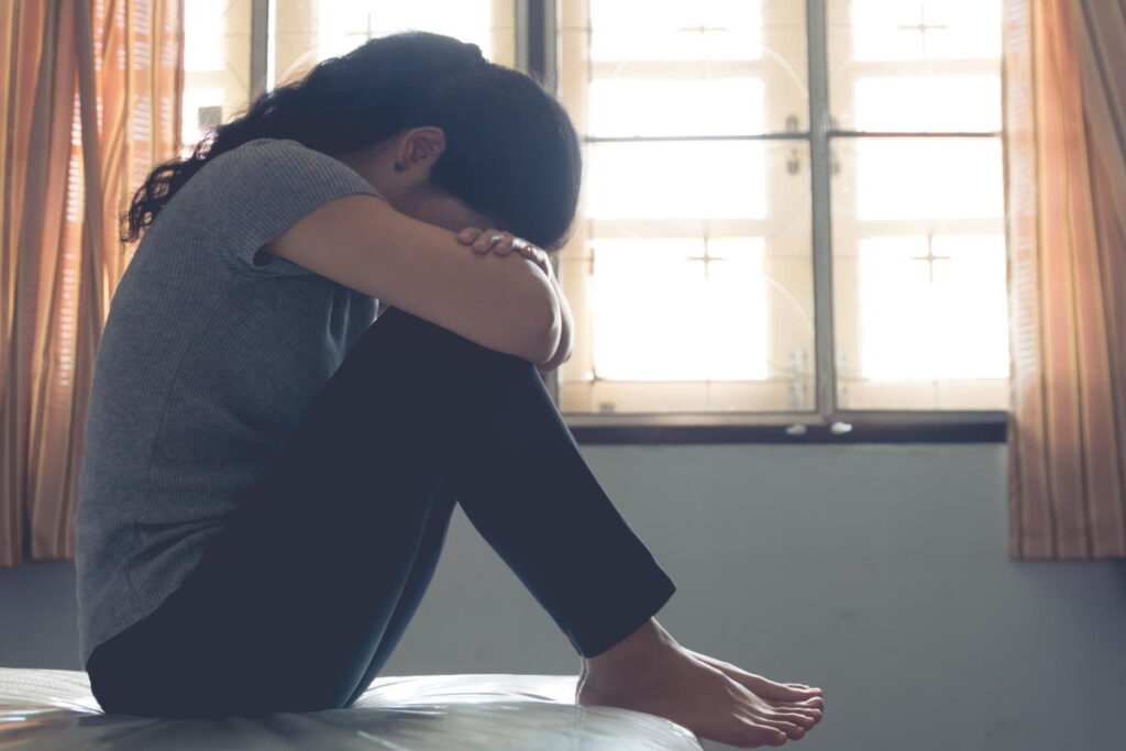 Depression asian woman is sad and stress in bedroom, close up at face